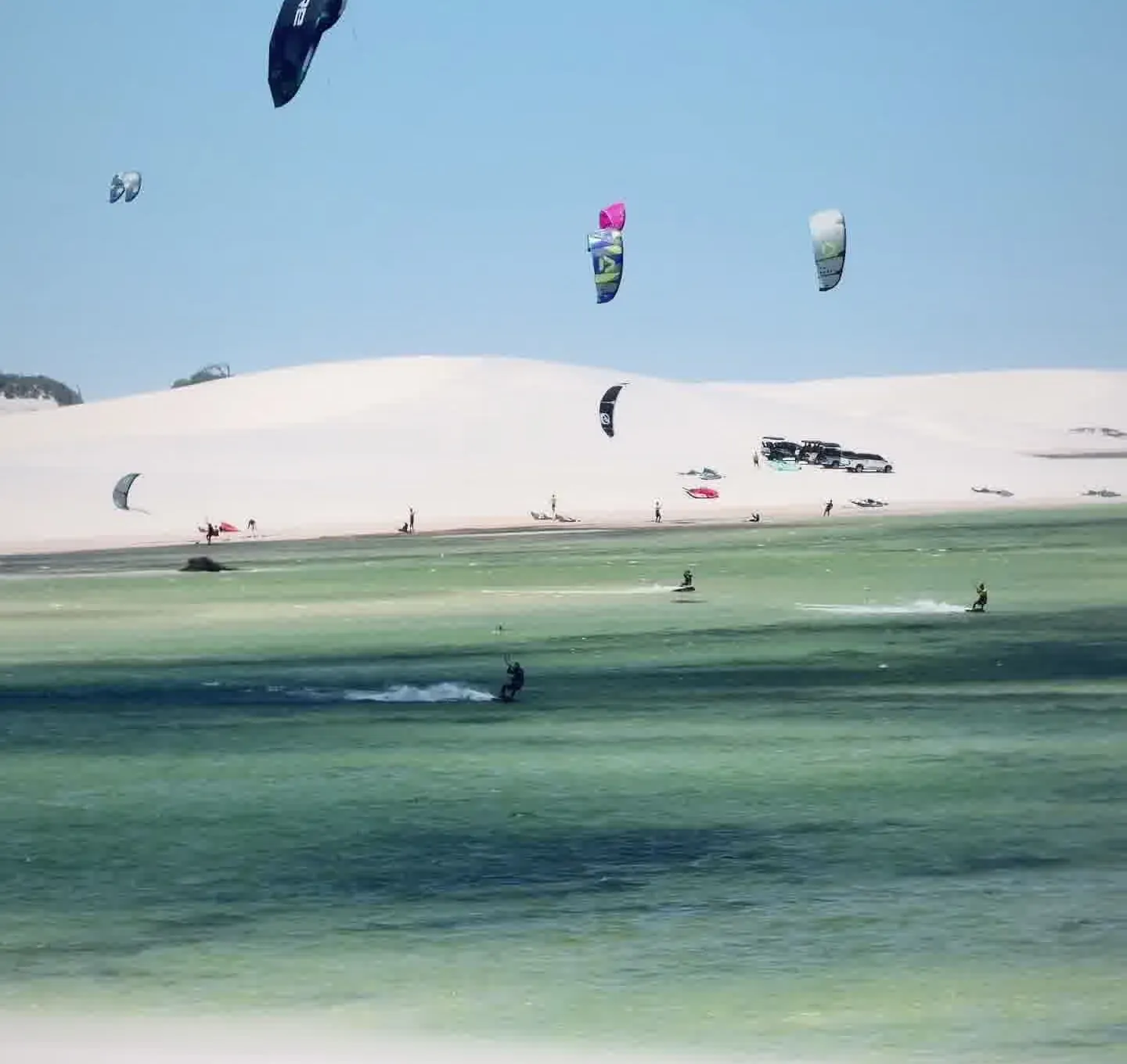 Lagoa entre dunas com kitesurfistas no litoral oeste do Ceará