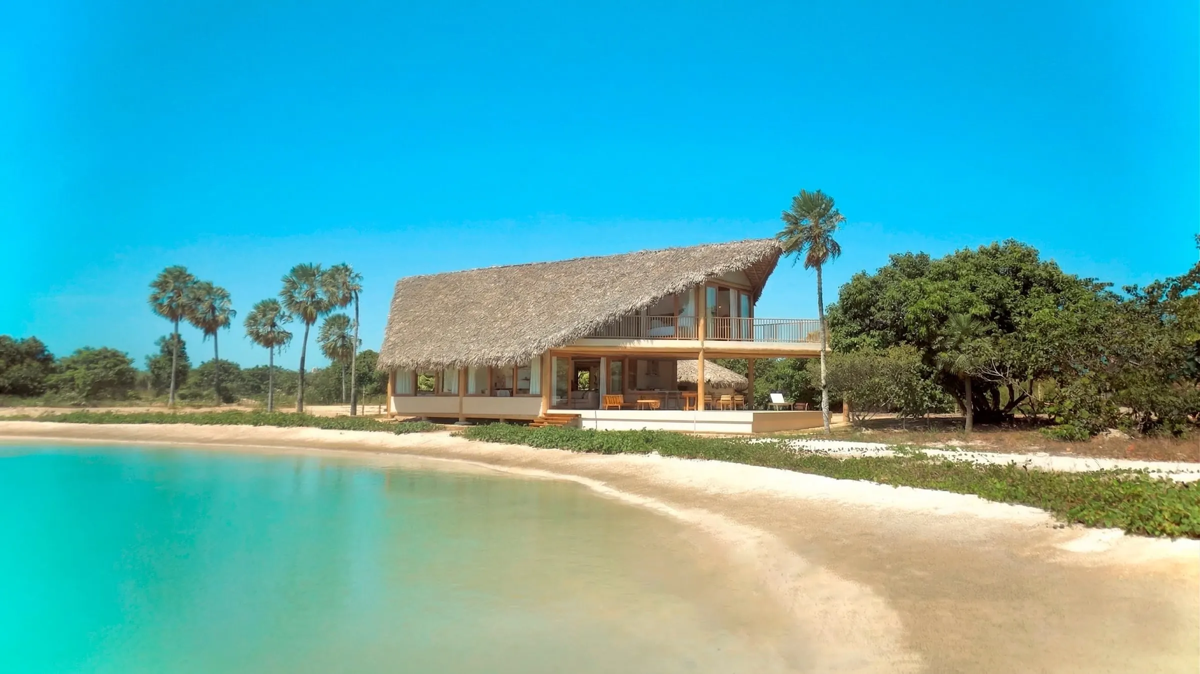 Casa com telhado de palha à beira da lagoa no Vila Carnaúba